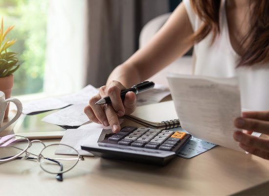 person at table using calculator going over finances
