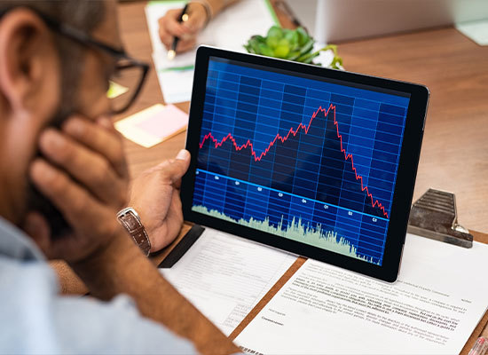 person holding tabet looking at stock market graph with poor performance
