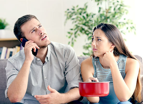 young home owners looking at a leak in their inherited home