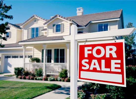 a for sale sign in front of a house