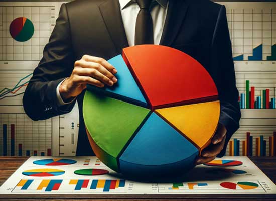 A person in a suit holds a large 3D pie chart over a table covered with various colorful charts and graphs.
