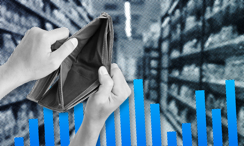 Hands holding an open and empty wallet in front of a graphical background depicting upward-trending bar charts. The image conveys financial difficulty or economic struggle.