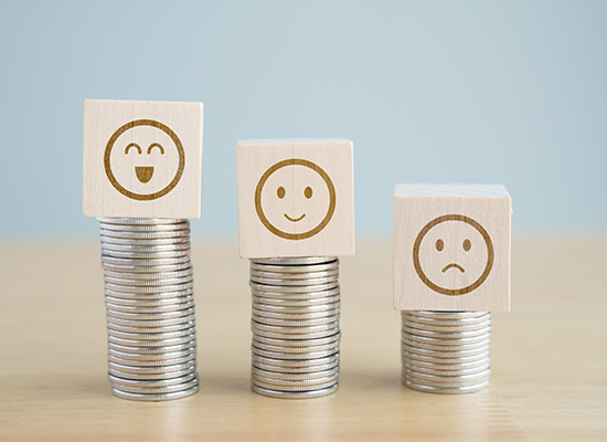 Three stacks of coins with happy, neutral, and sad faces on top, representing investors' varying experiences with volatility and downside protection