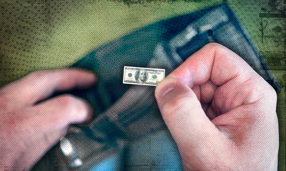 A close-up of hands holding a nearly empty wallet with a tiny hundred dollar bill