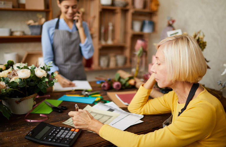 A worried senior woman florist on the phone