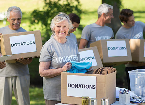 elderly people holding boxes labeled donations