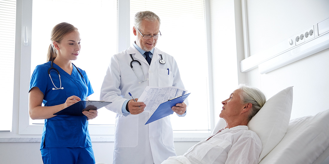 A doctor and nurse advising a senior woman in hospital