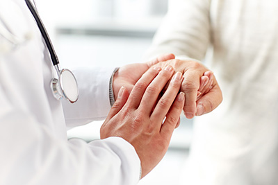 Doctor comforting, patient holding their hand