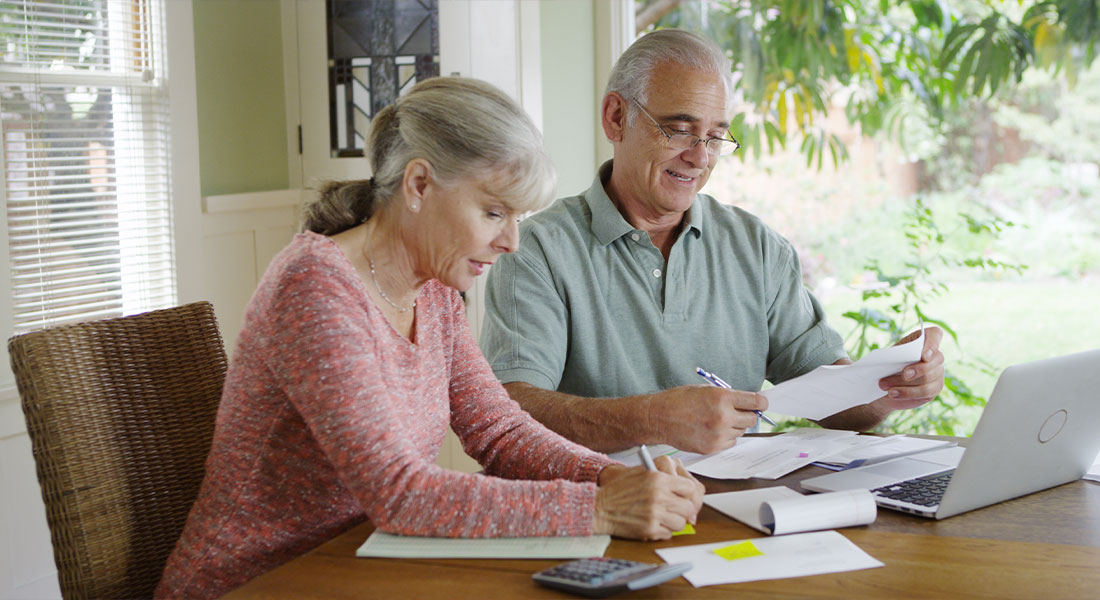 a senior couple reviewing their debt to try to make it disappear