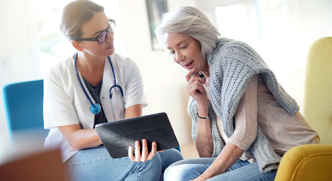 Nurse helping elderly woman patient with medicare