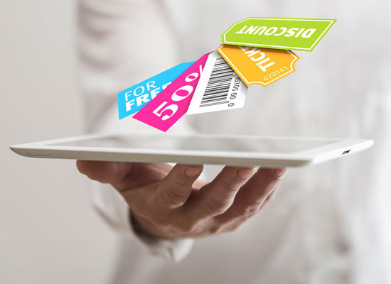 a hand holding a tablet with digital coupons displayed above