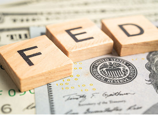 wooden blocks spelling FED on top of money