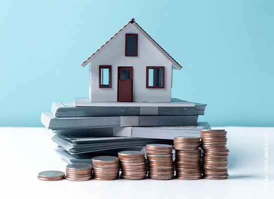 coins stacked in iteration with model home behind