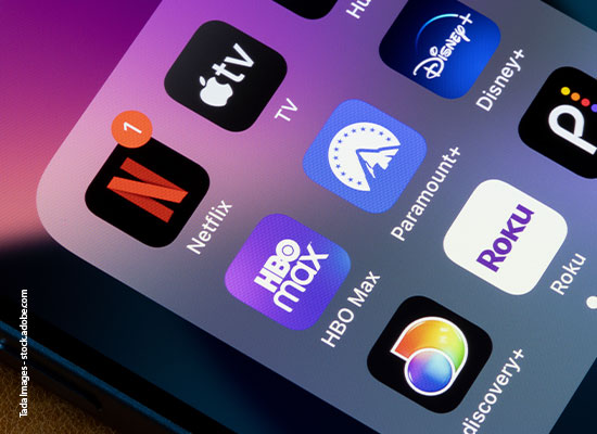 Close-up of a tablet screen displaying colorful app icons including Netflix, Apple tv, Disney+, Paramount+, HBO max