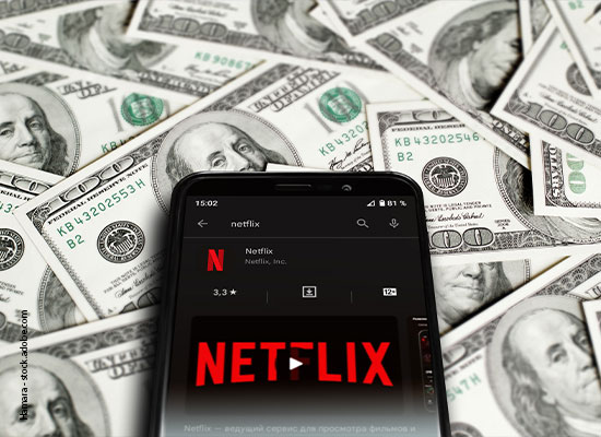 A smartphone displaying the netflix app surrounded by scattered us dollar bills.