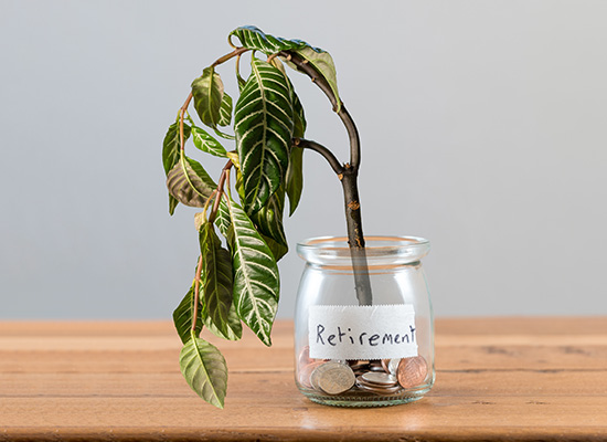 A wilted plant droops over a glass jar containing a few coins, which is labeled 'Retirement' on a label, symbolizing insufficient growth of retirement savings.