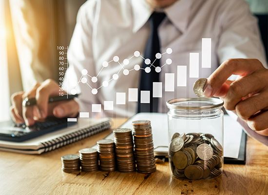 A businessman adding coins to a stack with a digital growth chart in the background, symbolizing retirement planning and investment growth.
