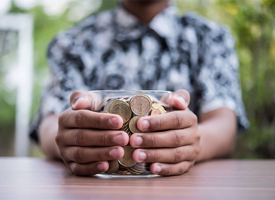 someone holding a jar of coins 