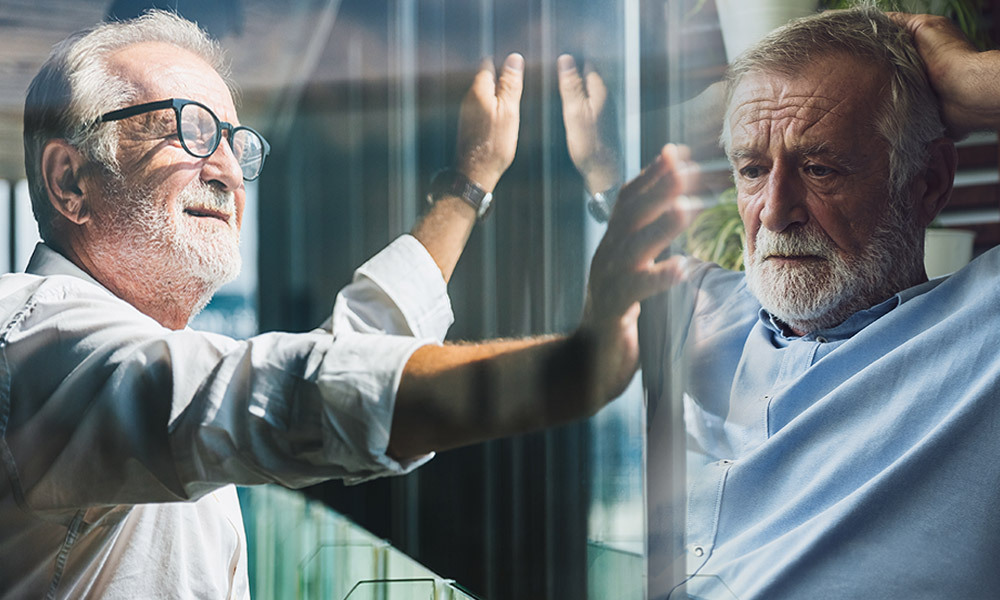 A man looking into window relieved but his reflection shows him stressed