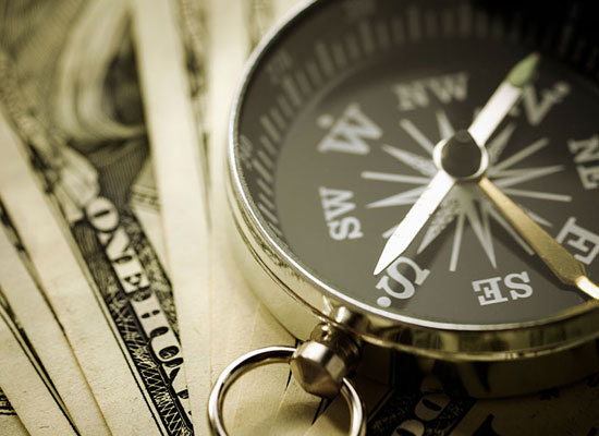 a compass lying on top of money