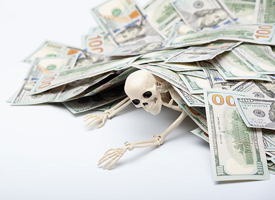 toy skeleton lying trapped under money