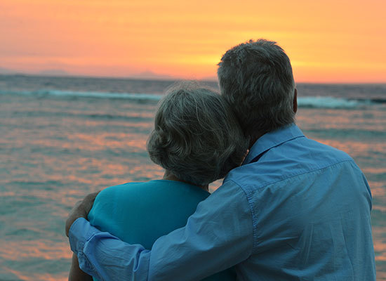 elderly couple looking into the sunset