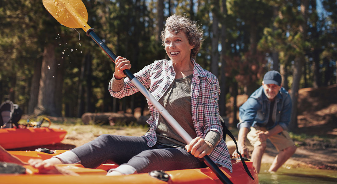 A senior couple engaging in healthy kyaking exercise on a river
