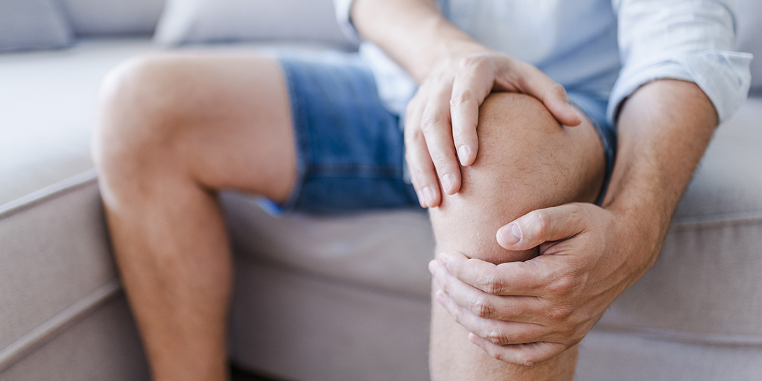 Older man dealing with knee pain and joint inflammation.