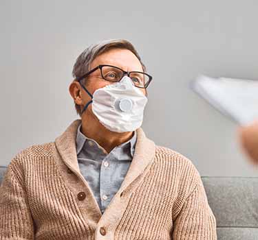Old man wearing mask in doctor's office