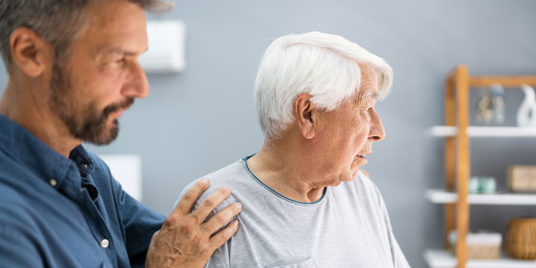 An adult son caring for his elderly father with alzheimers