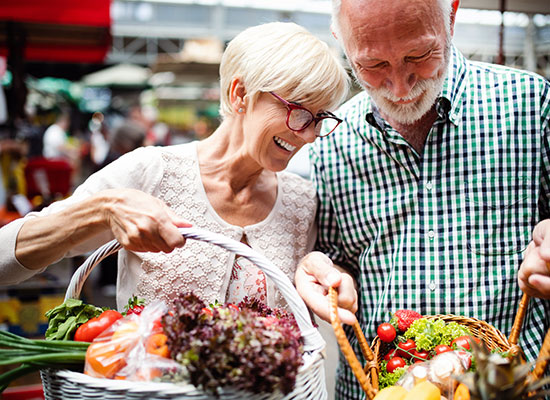 a senior couple shopping for plant based food at a market