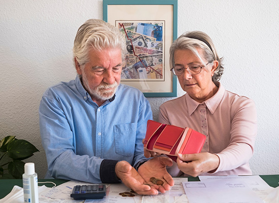 A senior couple reviewing their finances, underscoring the financial barriers to dental care for retirees.