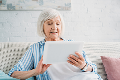 Senior woman using tablet on her couch