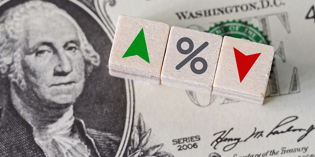 Dollar bill with tiles on top of it displaying percentage going up or down