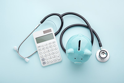 Piggy bank, calculator and stethoscope