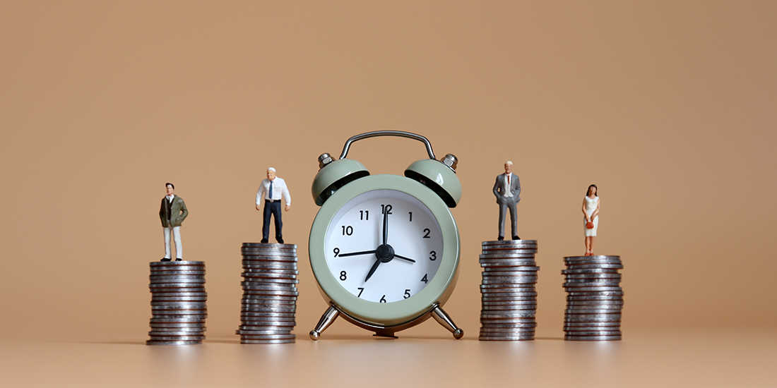 Alarm clock with people standing on stacks of coins