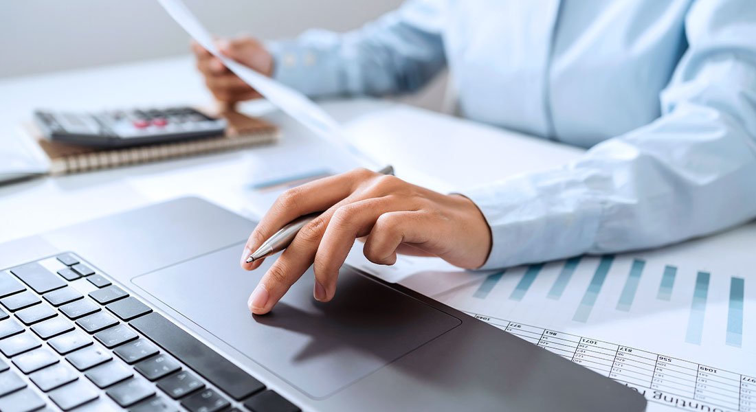 Checking annuity documents and numbers while using a laptop