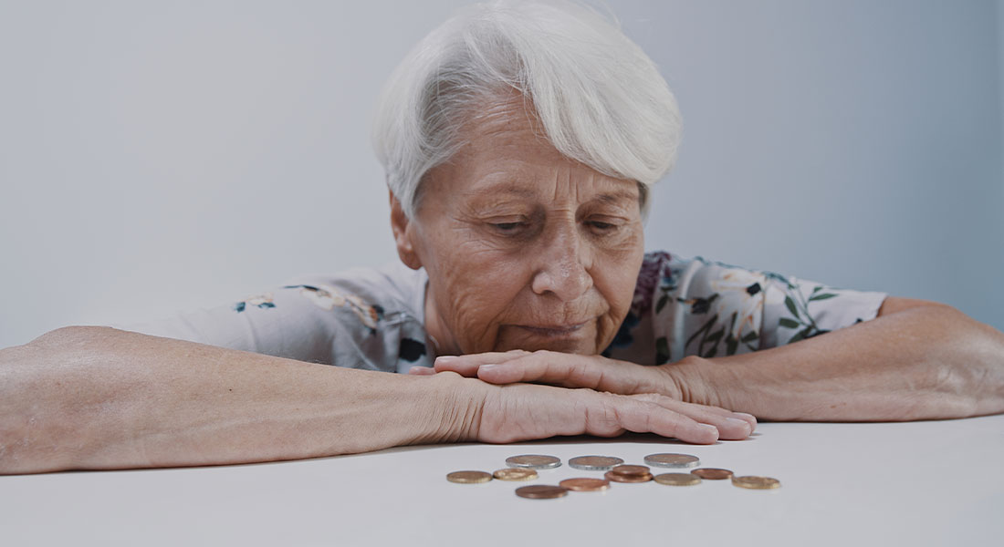 A woman disappointed while looking down at a few coins.
