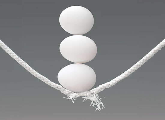 Three eggs balanced on a rope that is about to break