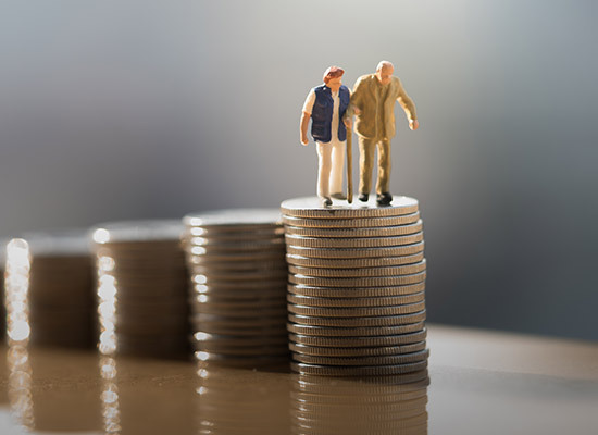 stacked coins with a toy elderly couple on the highest stack