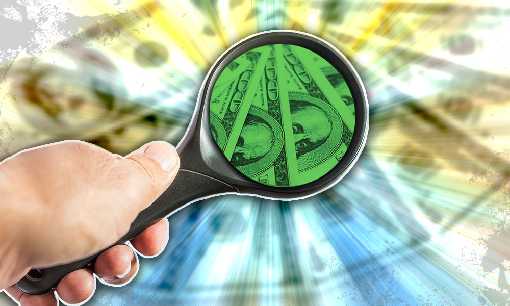 a magnifying glass looking at one hundred dollar bills