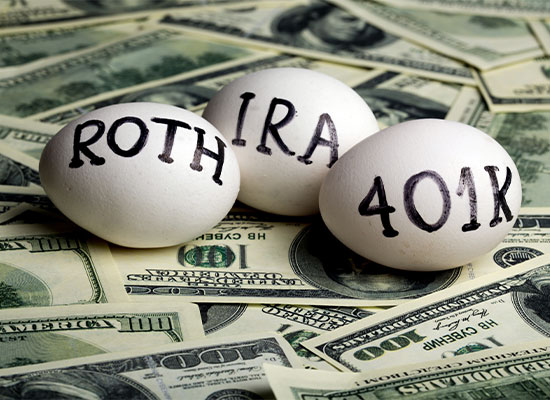 Three eggs on a bed of dollar bills, with the words 'roth', 'ira', and '401k' written on them, symbolizing retirement planning.