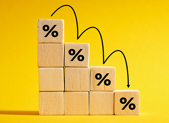Wooden blocks with percentage symbols and descending arrows, illustrating the concept of reduced Social Security benefits when claiming at age 62 or taking early retirement.