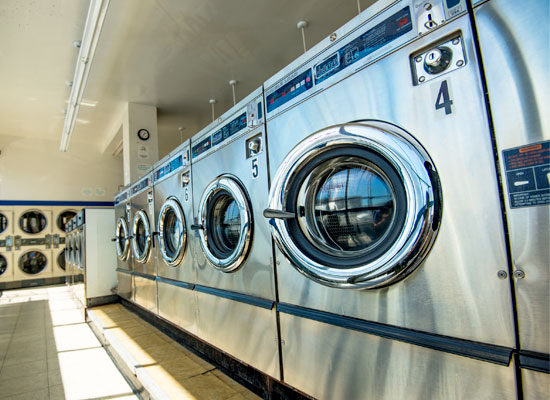 a line of dryers inside a laundromat