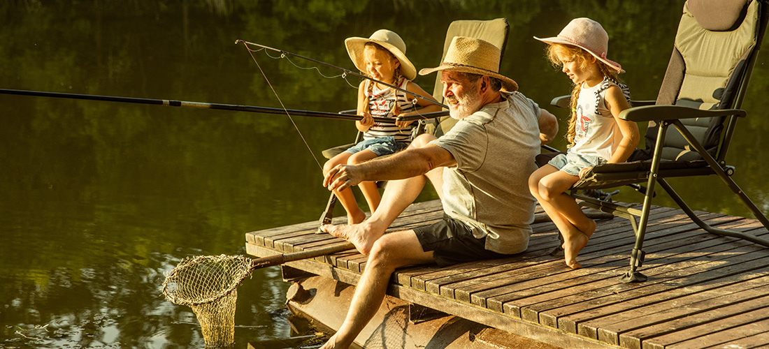 Grandpa fishing with his young granddaughters