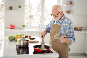 Senior man cooking healthy food for himself