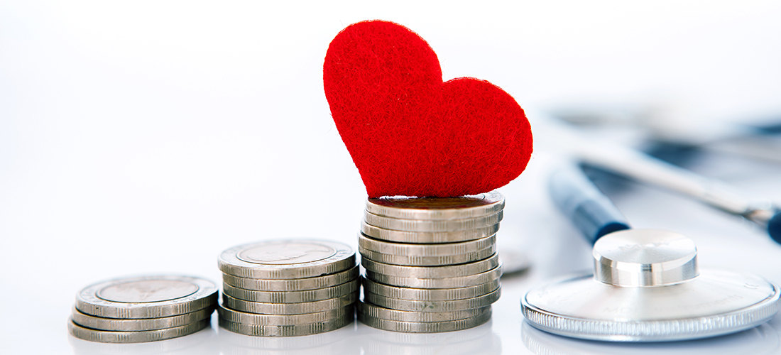 A paper heart cut out lying on top of stacked coins