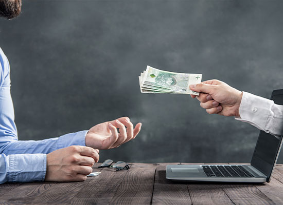 One man handing over money to another man.