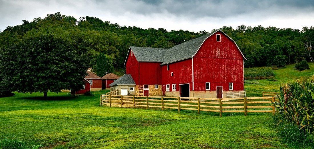 Large plot of farmland centered around a big red farm barn