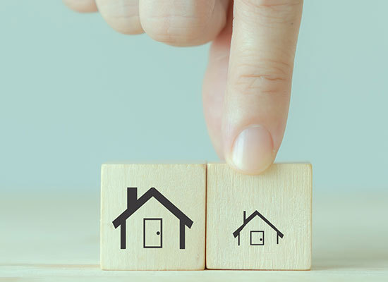 two wooden blocks each with a different size house printed on them